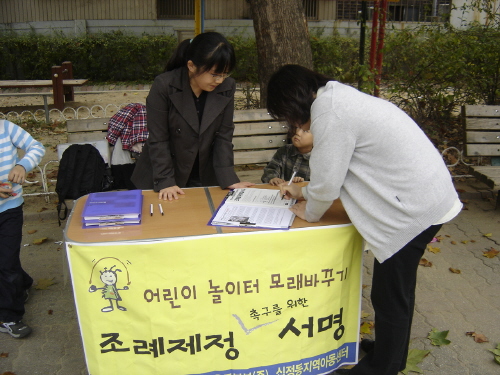 운동본부 관계자들이 어린이놀이터모래바꾸기 조례제정 촉구 서명을 받고있다 